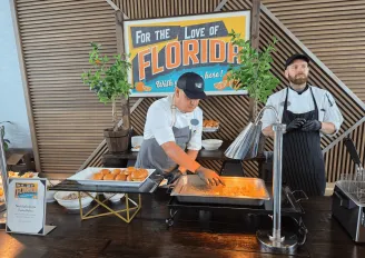 Buffet style food served by a chef in clean, modern restaurant with another chef stood behind.